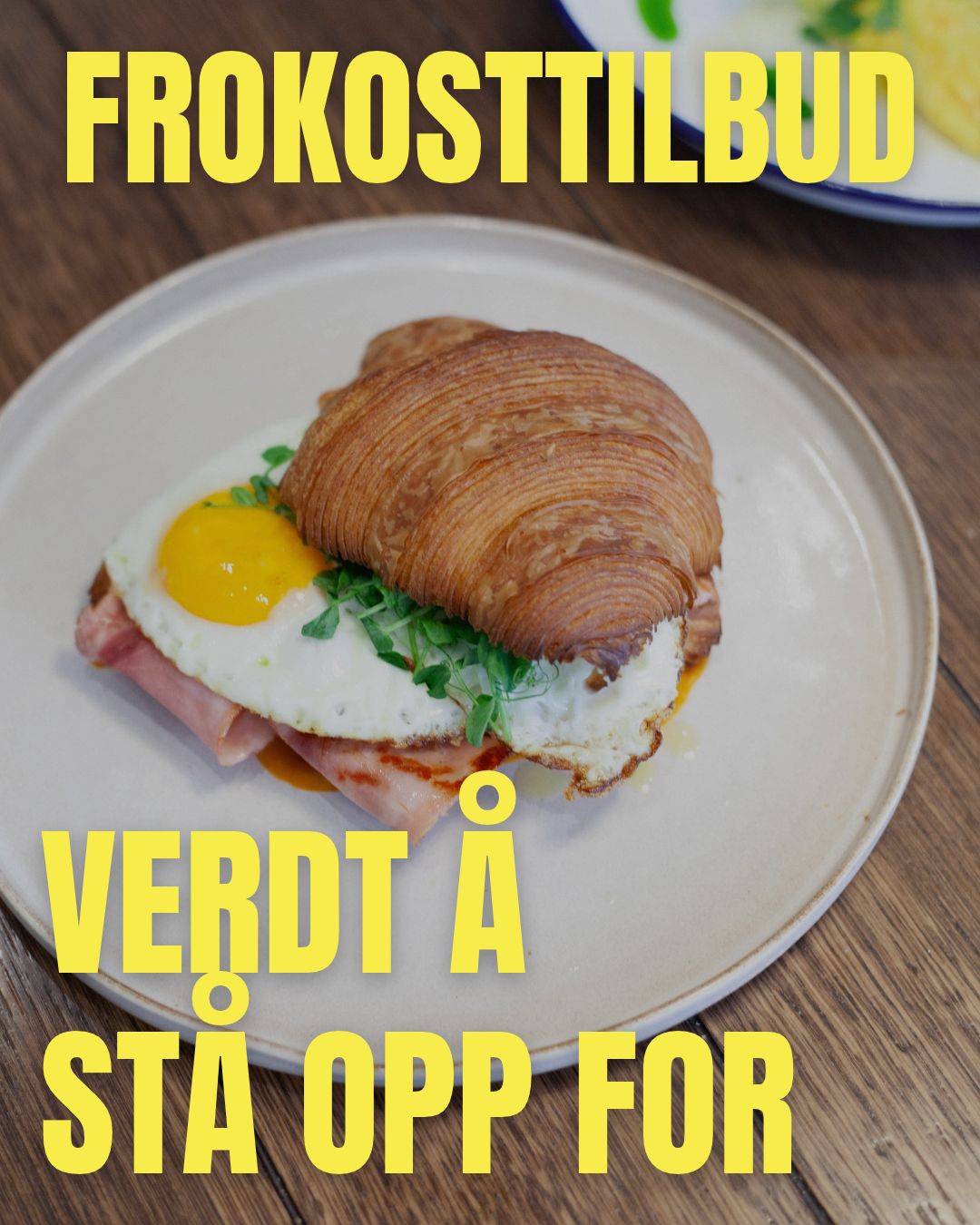 Innlegg for en kafé: croissant med egg og skinke med teksten Frokost, verdt å stå opp for