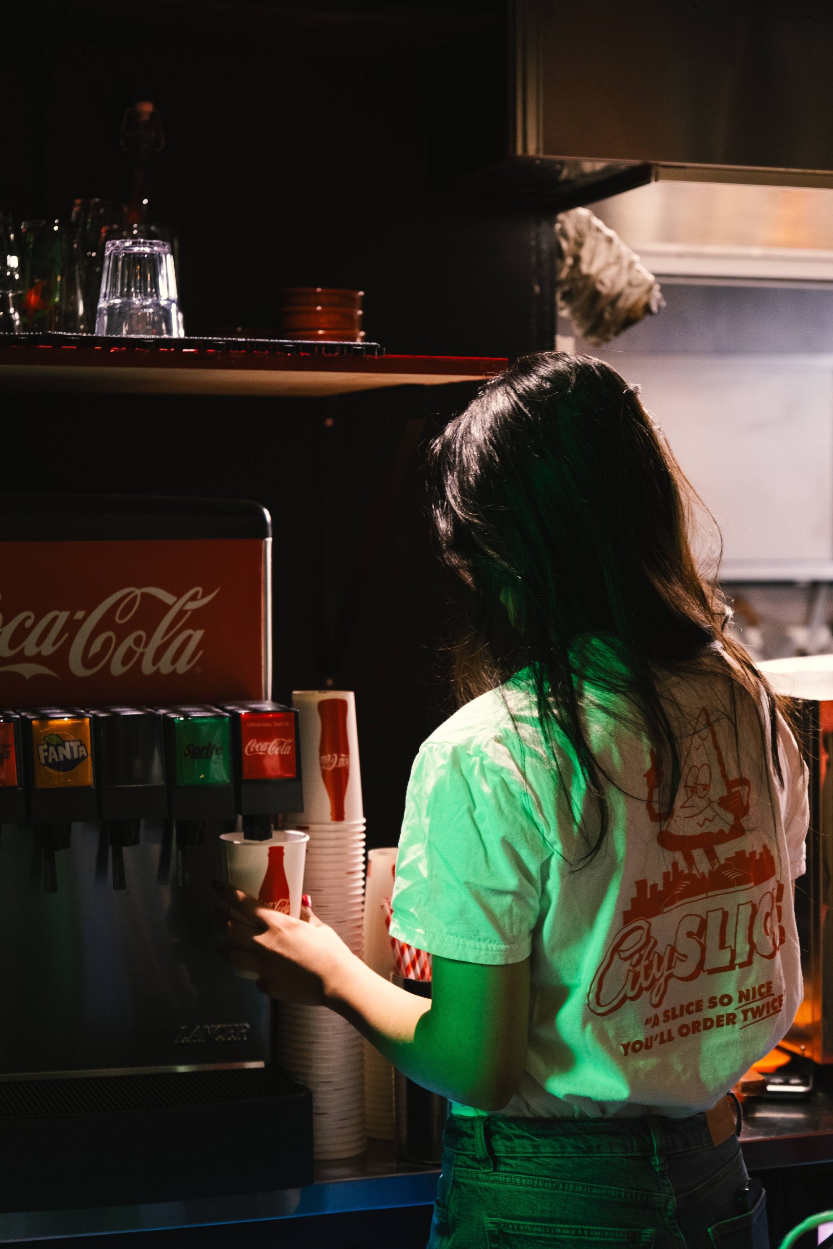 Girl using a coke dispenser Girl using a coke dispenser