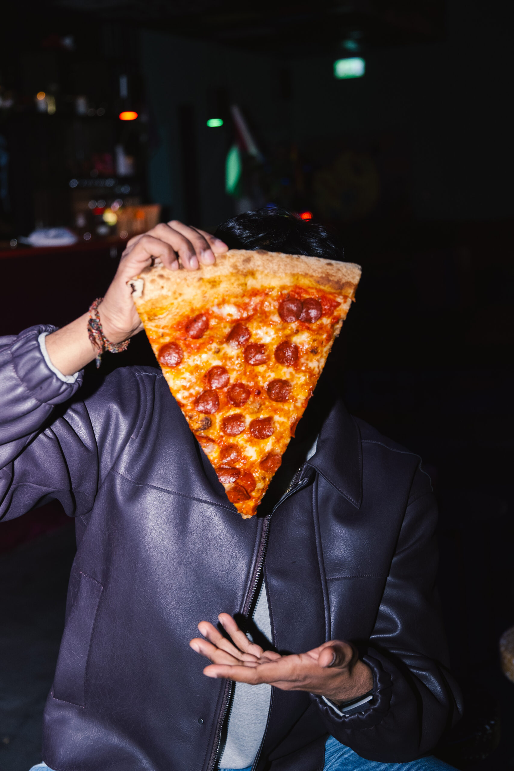 Gjest med et stort pizzastykke på City Slice i Oslo – fotografert av OsloPixel